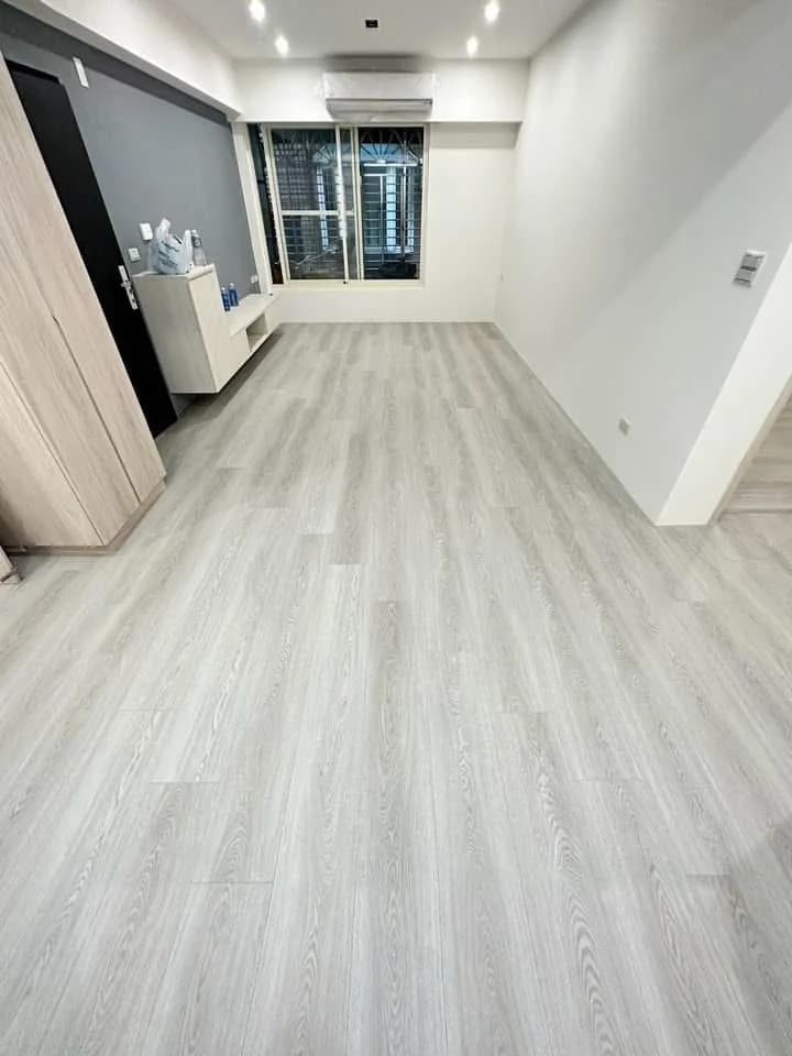 淺灰木紋石晶地板鋪設於客廳